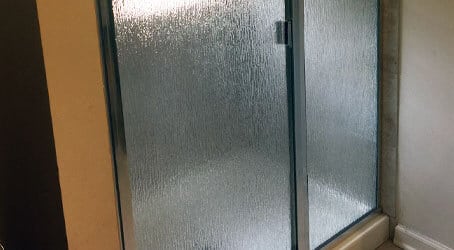 We install framed shower doors in a wide variety of styles, including this frosted glass pane look.