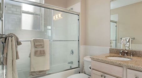 In a framed shower glass enclosure, a rolling shower door provides the convenience of an easy-to-open shower door that is also space-saving.